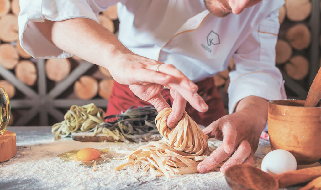 Chef cucina piatto tradizionale italiano, simbolo di ristorazione di qualità